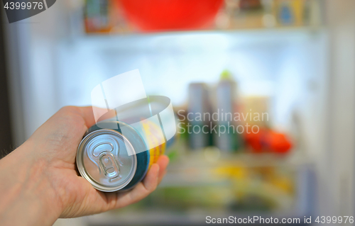 Image of Man taking beer from fridge