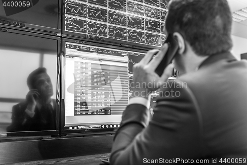 Image of Stock trader looking at market data on computer screens.