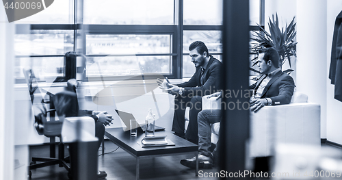 Image of Businessmen interviewing female candidate for job in modern corporate office.