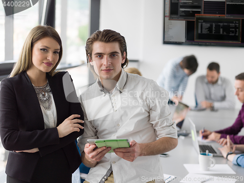 Image of Two Business People Working With Tablet in office