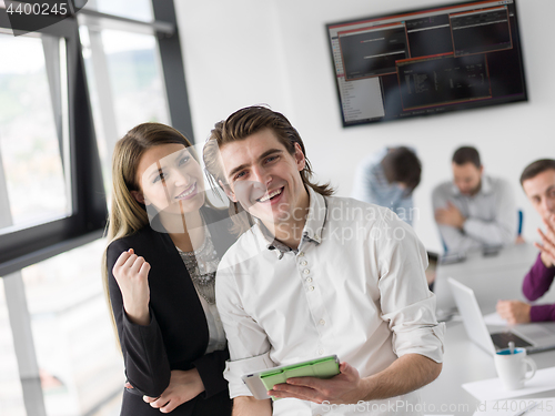 Image of Two Business People Working With Tablet in office