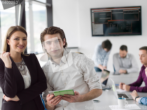 Image of Two Business People Working With Tablet in office