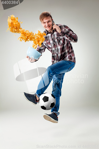 Image of Portrait of young man with smart phone and football ball