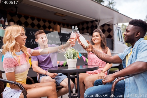 Image of friends clinking bottles with drinks at food truck