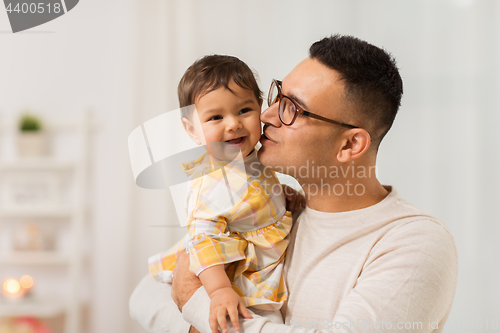 Image of happy father kissing little baby daughter at home