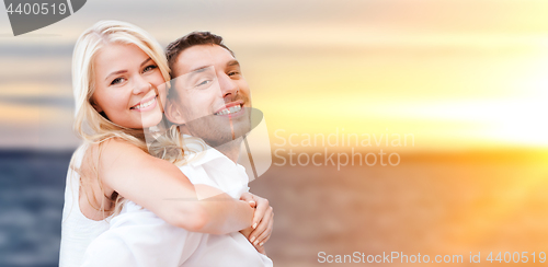 Image of happy couple hugging over sea background