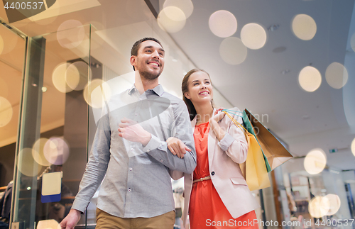 Image of happy young couple with shopping bags in mall