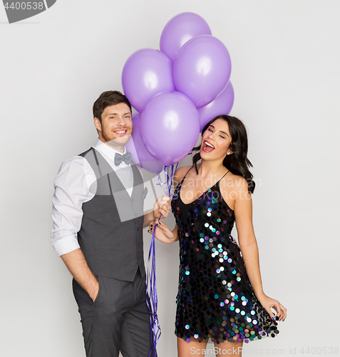 Image of happy couple with ultra violet balloons at party