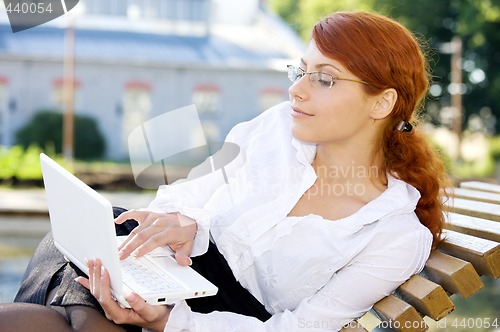 Image of businesswoman with laptop in the park