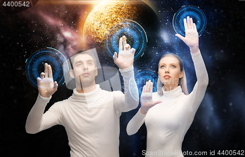 Image of couple using touch screen over space background