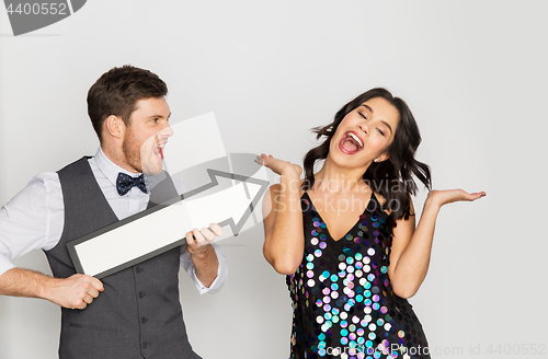 Image of happy couple with big arrow at party