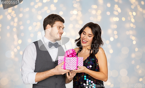 Image of happy couple with gift box at birthday party