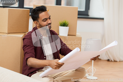 Image of man with blueprint and boxes moving to new home