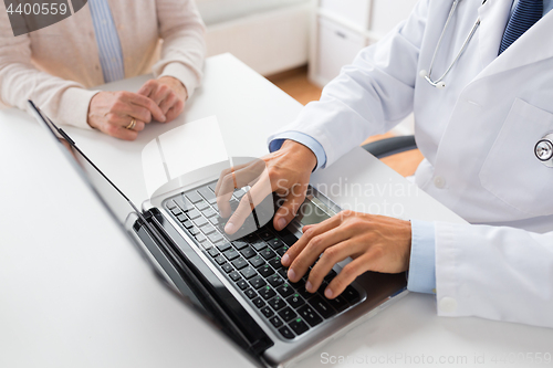 Image of senior woman and doctor with laptop at hospital