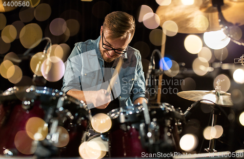 Image of male musician playing drums and cymbals at concert