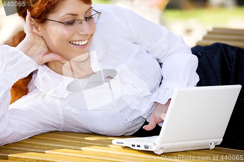 Image of businesswoman with laptop in the park