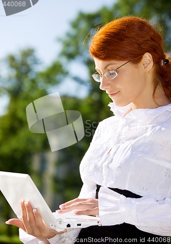 Image of businesswoman with laptop in the park