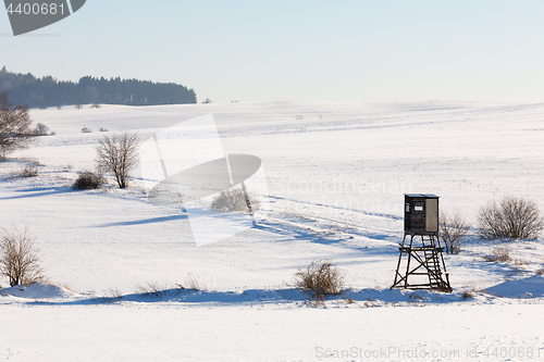 Image of winter frozen landscape with hunting tower on highland