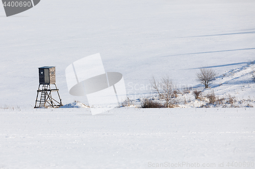 Image of winter frozen landscape with hunting tower on highland