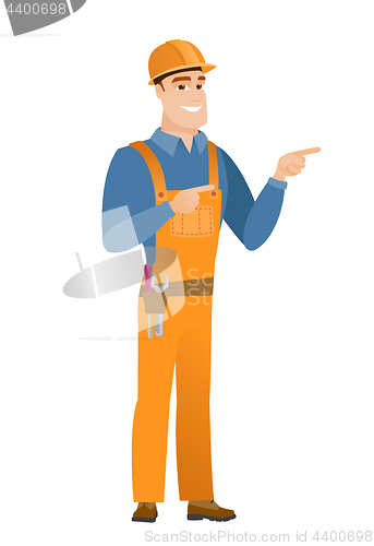 Image of Young caucasian builder pointing to the side.