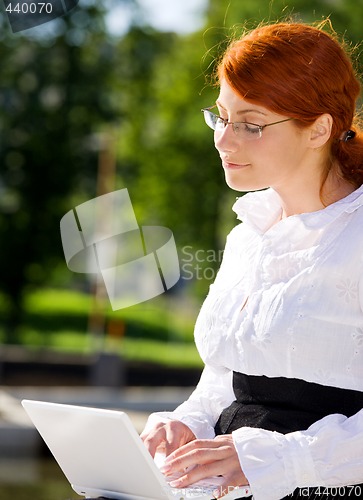 Image of businesswoman with laptop in the park