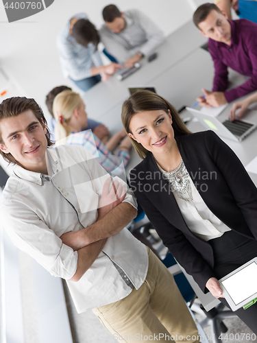 Image of Two Business People Working With Tablet in office