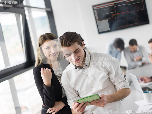 Image of Two Business People Working With Tablet in office