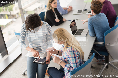 Image of Pretty Businesswomen Using Tablet In Office Building during conf