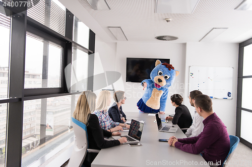 Image of boss dresed as bear having fun with business people in trendy of