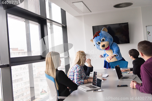 Image of boss dresed as bear having fun with business people in trendy of