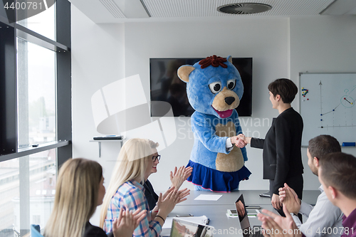 Image of boss dresed as bear having fun with business people in trendy of