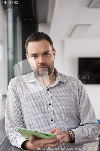 Image of Businessman Using Tablet In Office Building by window