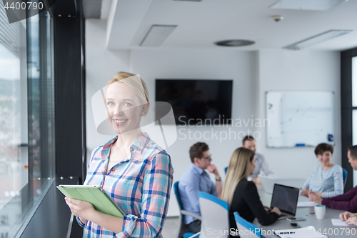 Image of Pretty Businesswoman Using Tablet In Office Building by window