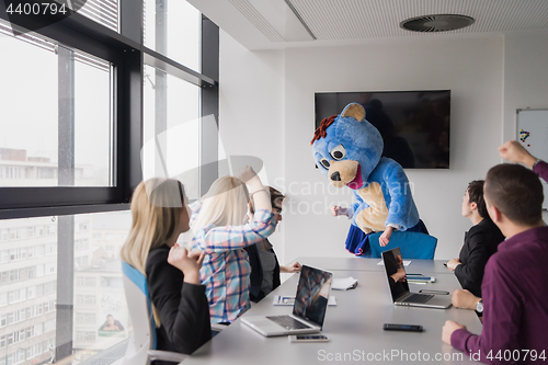 Image of boss dresed as bear having fun with business people in trendy of