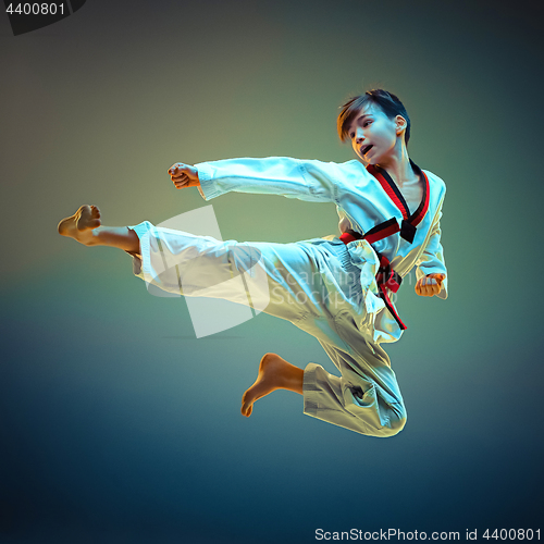 Image of Young boy training karate on blue background