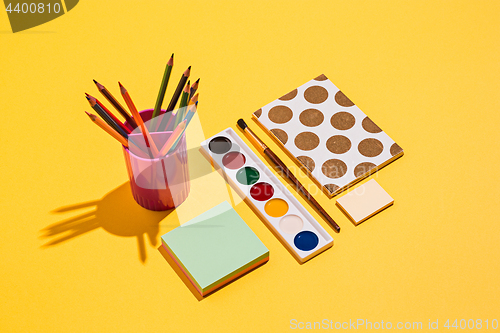 Image of Artistic tools - brushes, watercolor paint, notebook