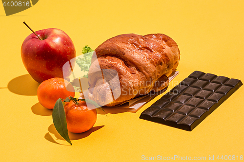 Image of The apple, chocolate and croissants on yellow background