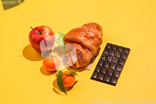 Image of The apple, chocolate and croissants on yellow background