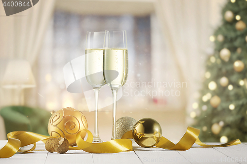 Image of Glasses with champagne over sparkling holiday background