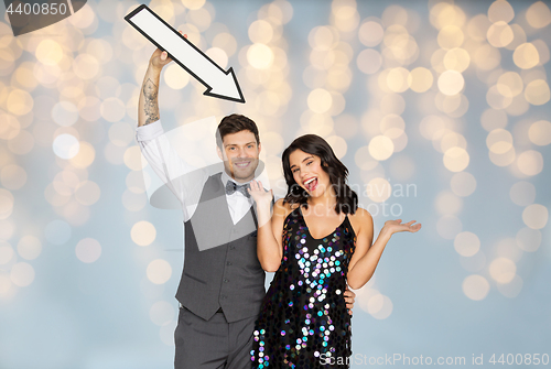 Image of happy couple with big arrow at party