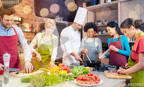 Image of happy friends and chef cook cooking in kitchen