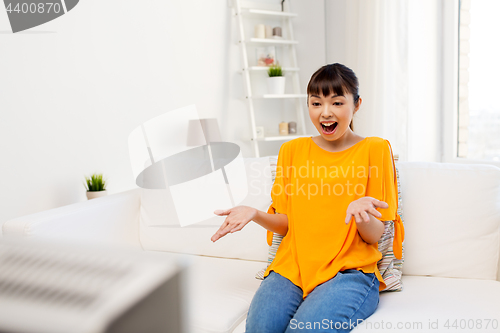 Image of happy asian woman with watching tv at home