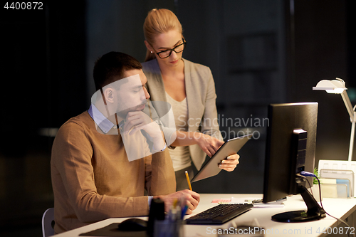 Image of business team with tablet pc late at office