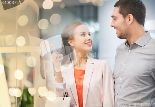 Image of happy young couple with shopping bags in mall