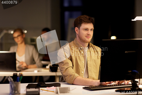 Image of man with computer working late at night office