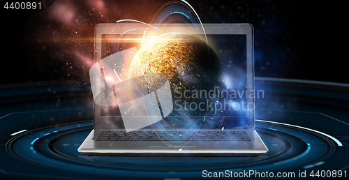 Image of laptop with virtual planet and space hologram