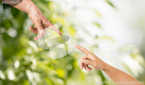 Image of close up of senior and young woman hands