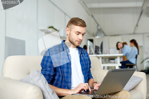 Image of man with laptop working at office