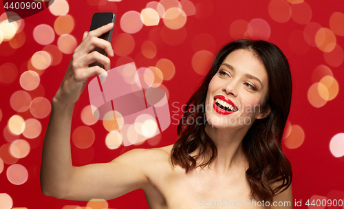 Image of beautiful woman taking selfie by smartphone