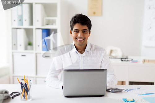 Image of businessman with laptop and papers at office